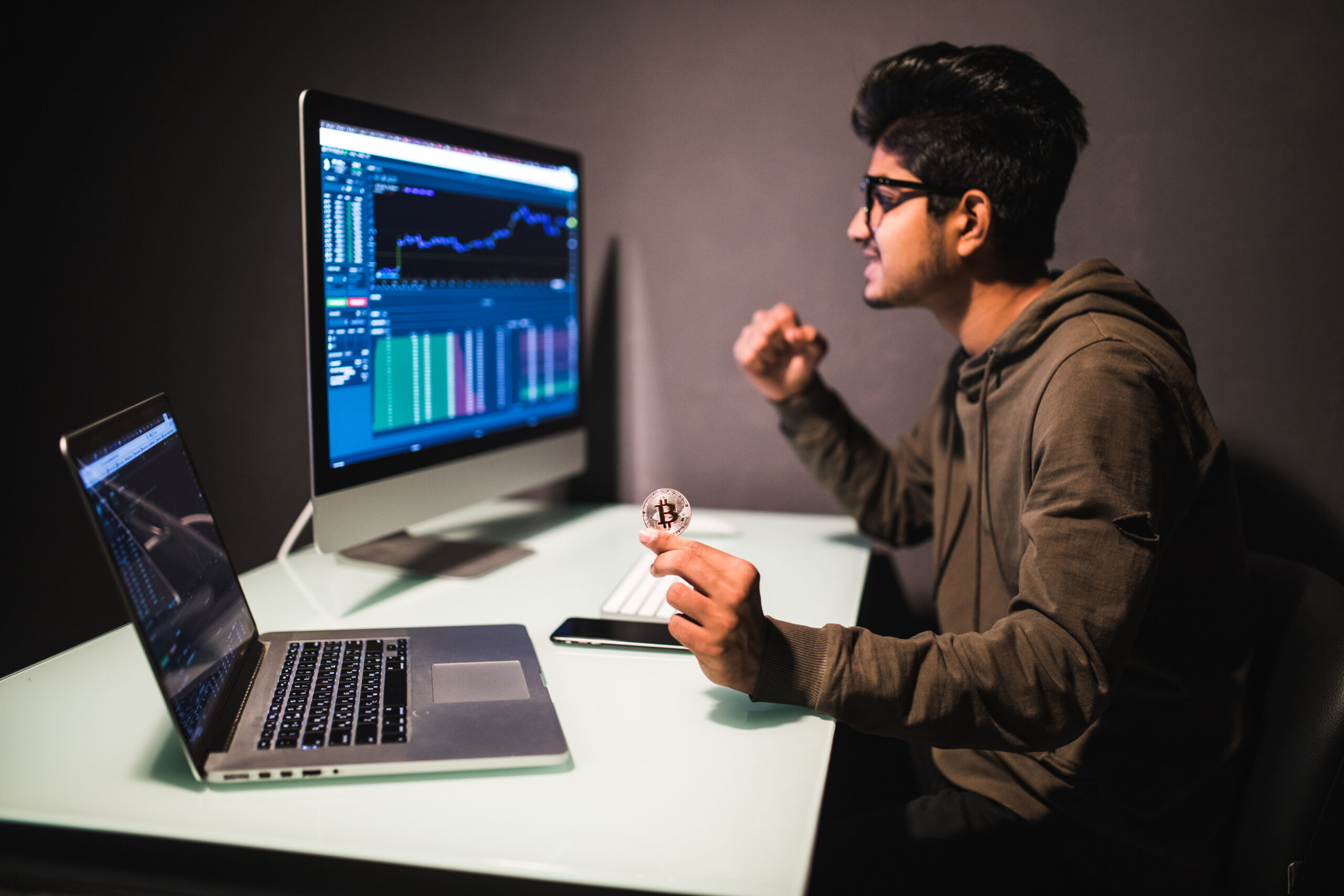 Indian trader checking stock trading data analysis concept working in office with financial graph on computer monitors